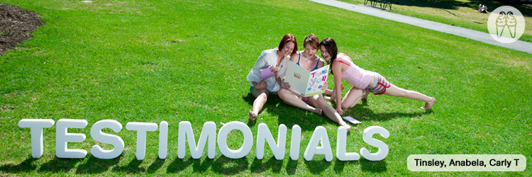 Three girls sitting together reading in the park.